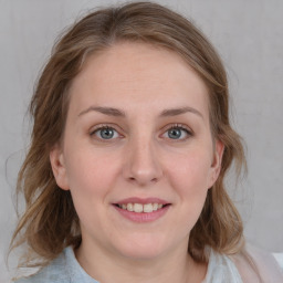 Joyful white young-adult female with medium  brown hair and blue eyes