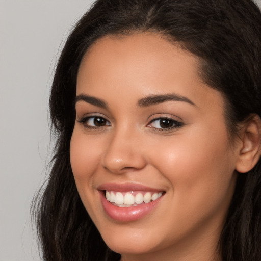 Joyful latino young-adult female with long  brown hair and brown eyes