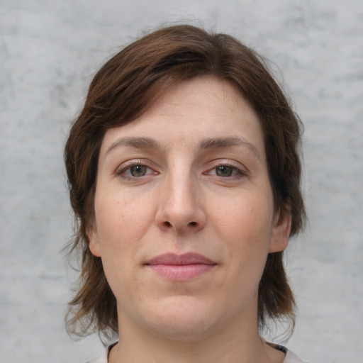 Joyful white adult female with medium  brown hair and grey eyes