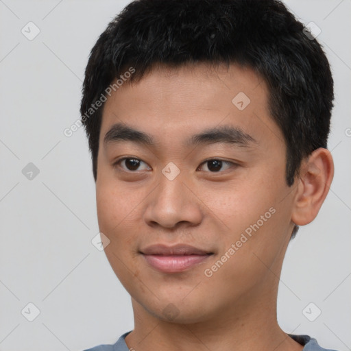 Joyful asian young-adult male with short  brown hair and brown eyes