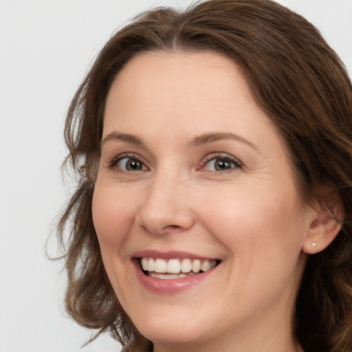 Joyful white young-adult female with long  brown hair and green eyes