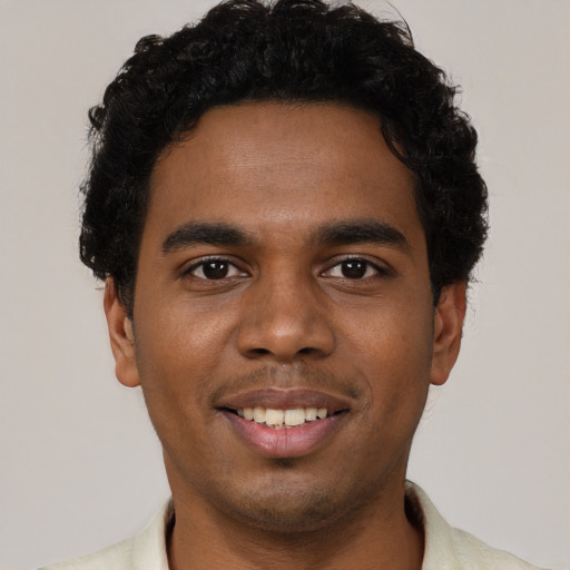 Joyful black young-adult male with short  black hair and brown eyes