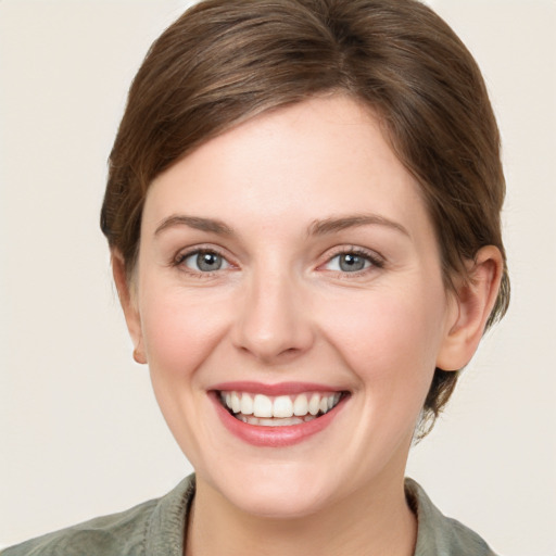 Joyful white young-adult female with medium  brown hair and grey eyes