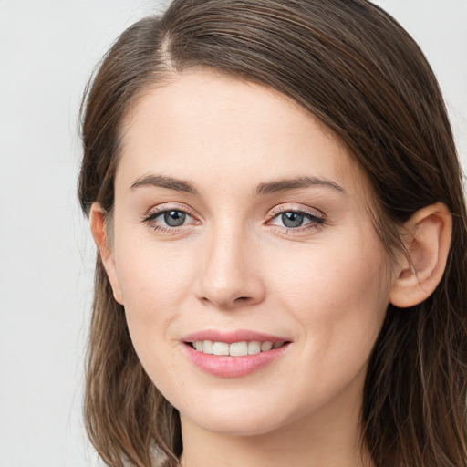 Joyful white young-adult female with long  brown hair and grey eyes