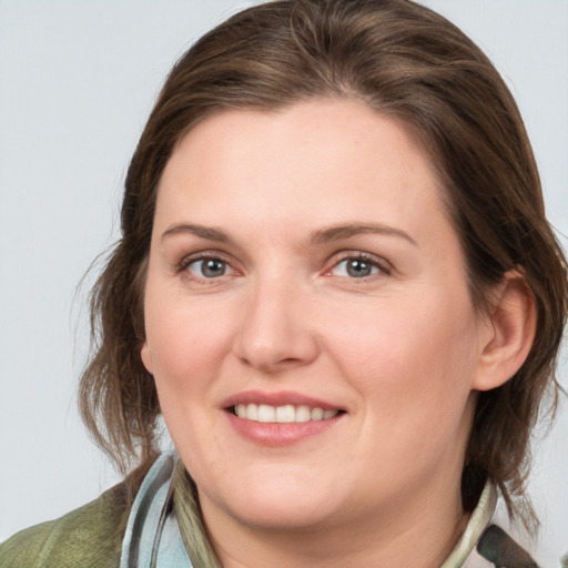 Joyful white young-adult female with medium  brown hair and grey eyes