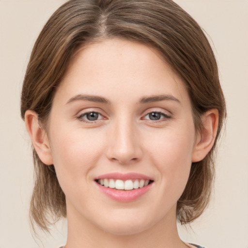 Joyful white young-adult female with medium  brown hair and green eyes