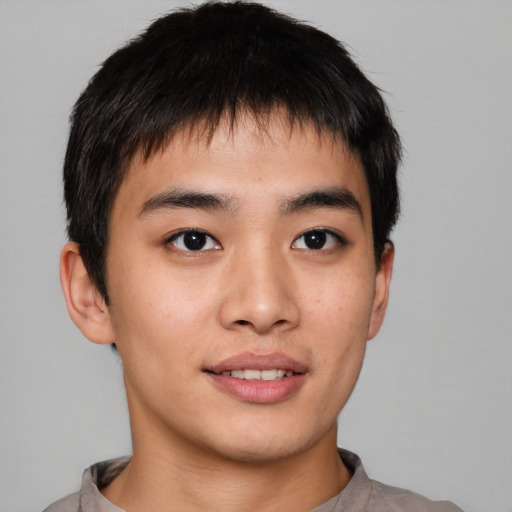 Joyful asian young-adult male with short  brown hair and brown eyes