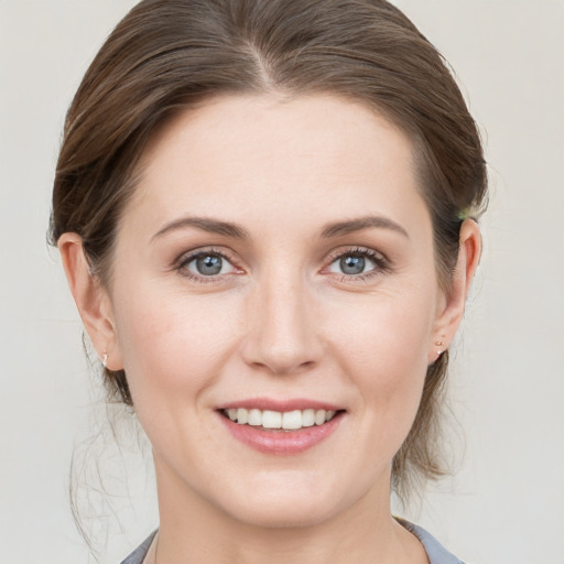 Joyful white young-adult female with medium  brown hair and blue eyes