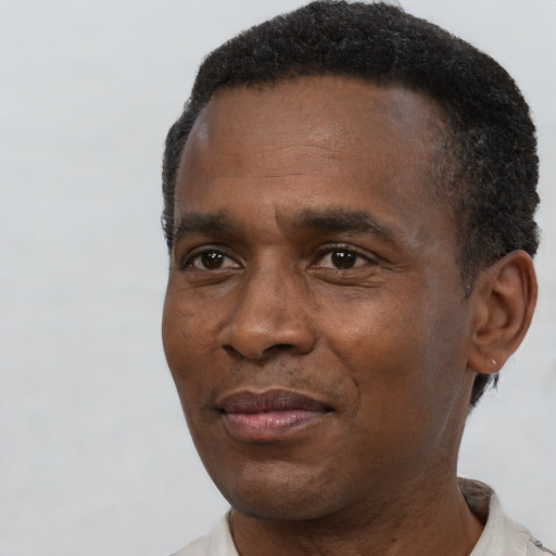 Joyful black adult male with short  black hair and brown eyes