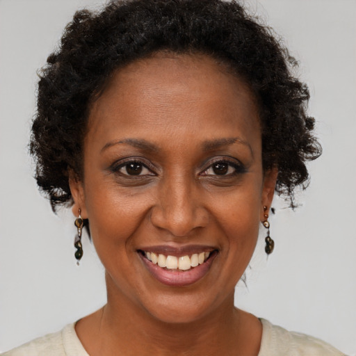 Joyful black adult female with short  brown hair and brown eyes