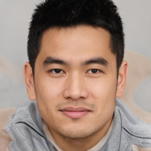 Joyful asian young-adult male with short  brown hair and brown eyes