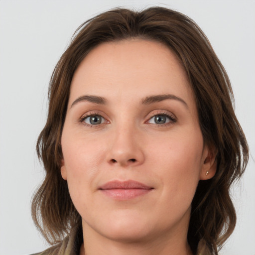 Joyful white young-adult female with medium  brown hair and grey eyes