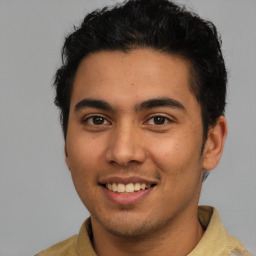 Joyful latino young-adult male with short  brown hair and brown eyes