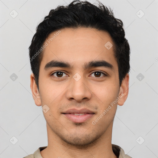 Joyful latino young-adult male with short  black hair and brown eyes