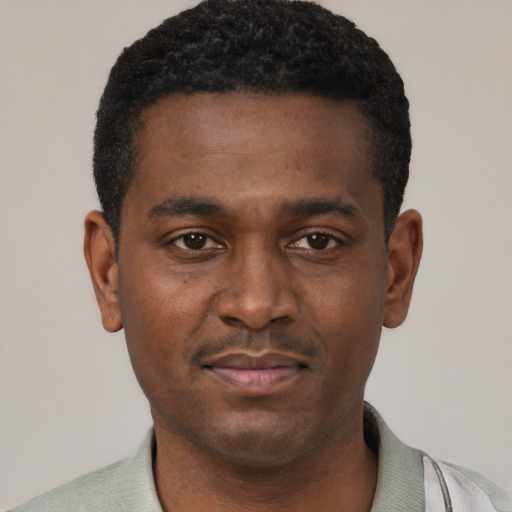 Joyful black young-adult male with short  black hair and brown eyes