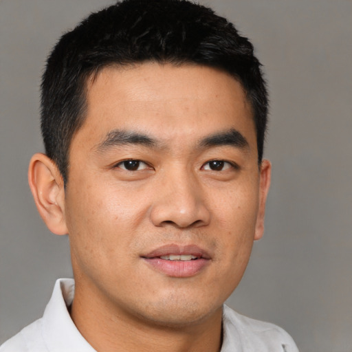 Joyful asian young-adult male with short  black hair and brown eyes