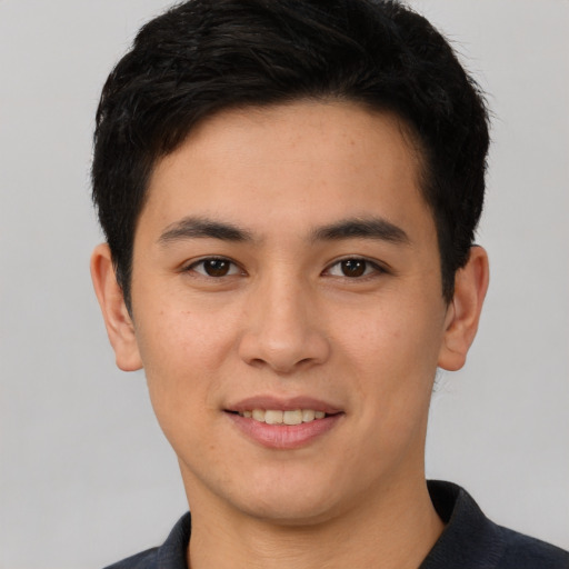 Joyful white young-adult male with short  black hair and brown eyes