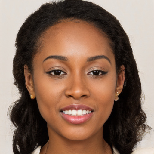 Joyful black young-adult female with long  brown hair and brown eyes