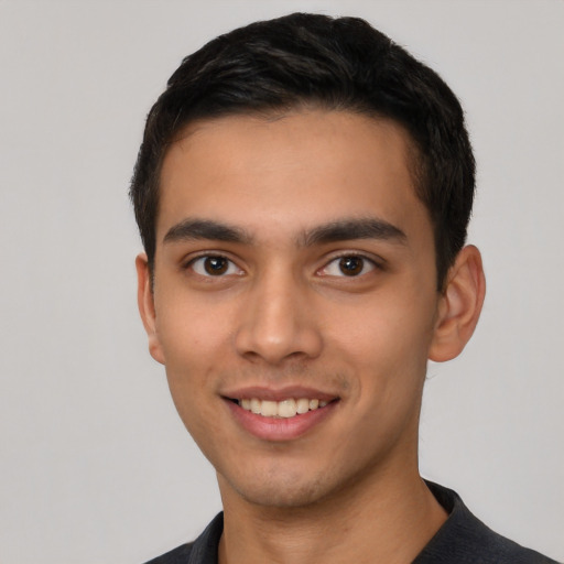 Joyful latino young-adult male with short  black hair and brown eyes