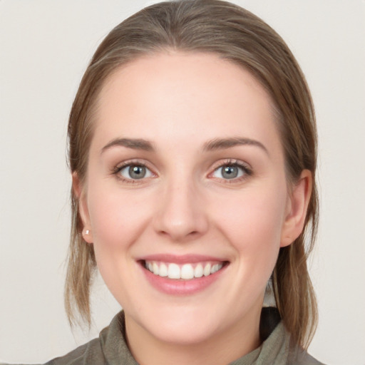 Joyful white young-adult female with medium  brown hair and blue eyes