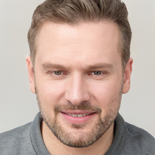 Joyful white adult male with short  brown hair and grey eyes