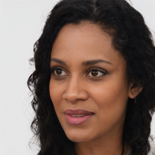 Joyful black young-adult female with long  black hair and brown eyes