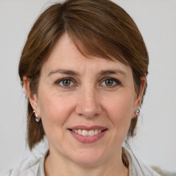 Joyful white adult female with medium  brown hair and grey eyes