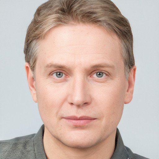 Joyful white adult male with short  brown hair and blue eyes