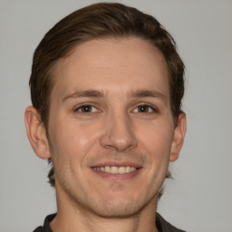 Joyful white young-adult male with short  brown hair and grey eyes