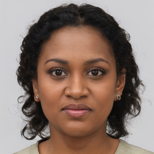 Joyful black young-adult female with long  brown hair and brown eyes