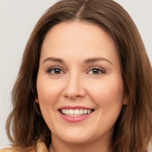 Joyful white young-adult female with long  brown hair and brown eyes