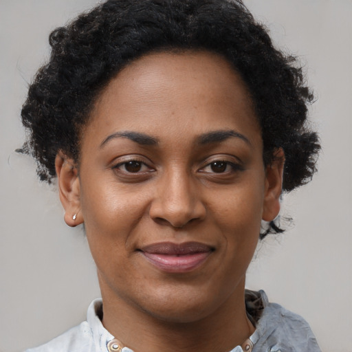 Joyful black adult female with short  brown hair and brown eyes