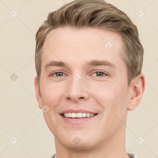 Joyful white young-adult male with short  brown hair and grey eyes