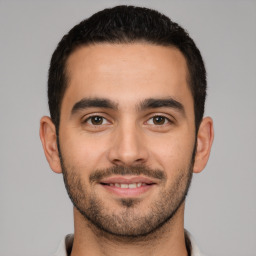 Joyful white young-adult male with short  black hair and brown eyes