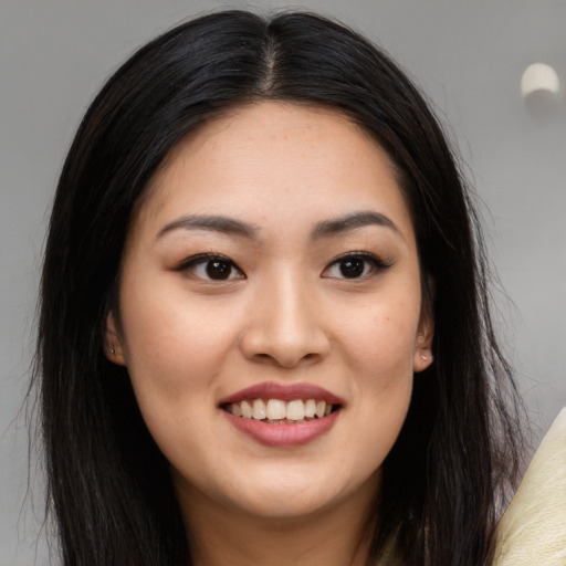 Joyful latino young-adult female with long  brown hair and brown eyes