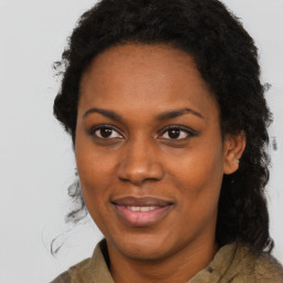 Joyful black adult female with long  brown hair and brown eyes