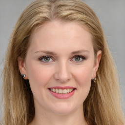 Joyful white young-adult female with long  brown hair and blue eyes