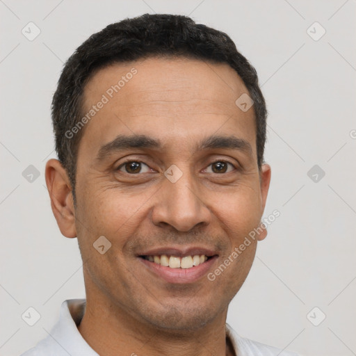 Joyful latino young-adult male with short  brown hair and brown eyes