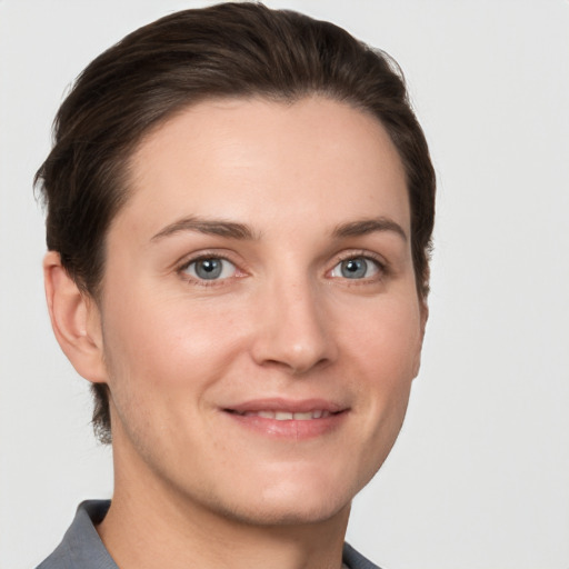 Joyful white young-adult female with short  brown hair and grey eyes