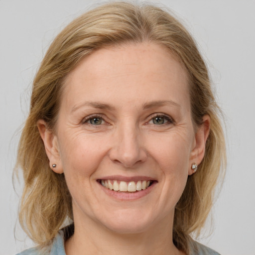 Joyful white adult female with medium  brown hair and blue eyes