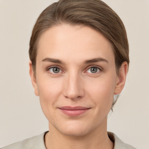 Joyful white young-adult female with short  brown hair and grey eyes