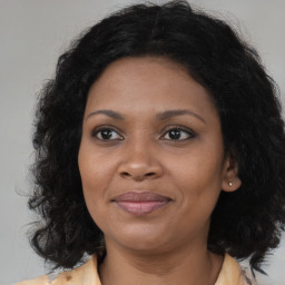 Joyful black adult female with medium  brown hair and brown eyes