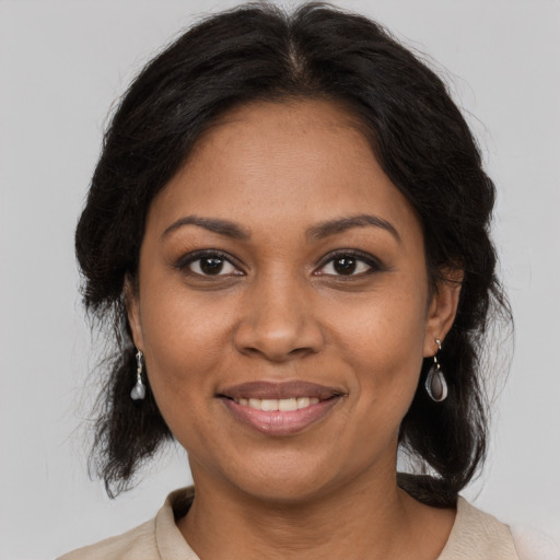 Joyful black adult female with long  brown hair and brown eyes