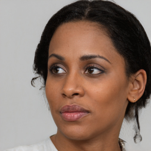 Neutral black young-adult female with medium  brown hair and brown eyes