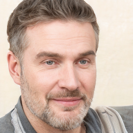 Joyful white adult male with short  brown hair and grey eyes