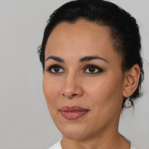 Joyful latino young-adult female with short  black hair and brown eyes