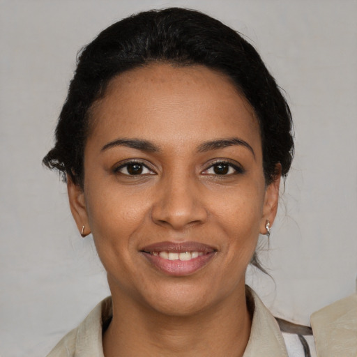 Joyful black young-adult female with short  brown hair and brown eyes