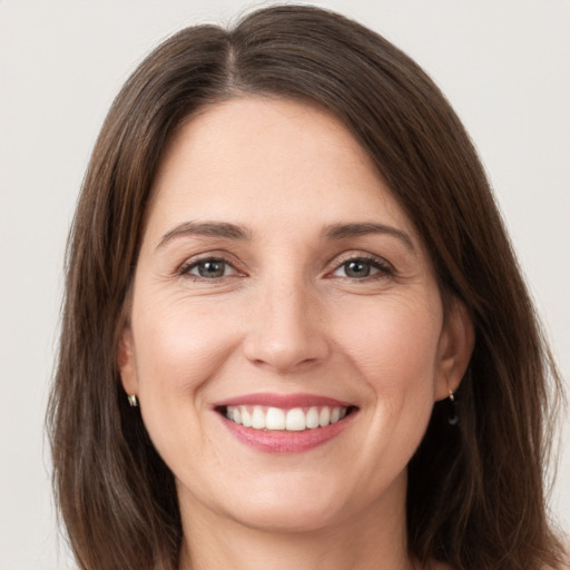 Joyful white young-adult female with long  brown hair and grey eyes