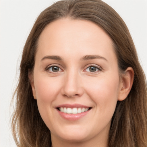 Joyful white young-adult female with long  brown hair and grey eyes