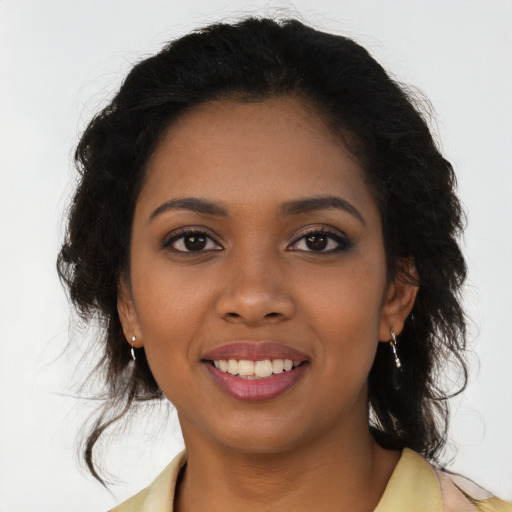 Joyful black young-adult female with long  brown hair and brown eyes
